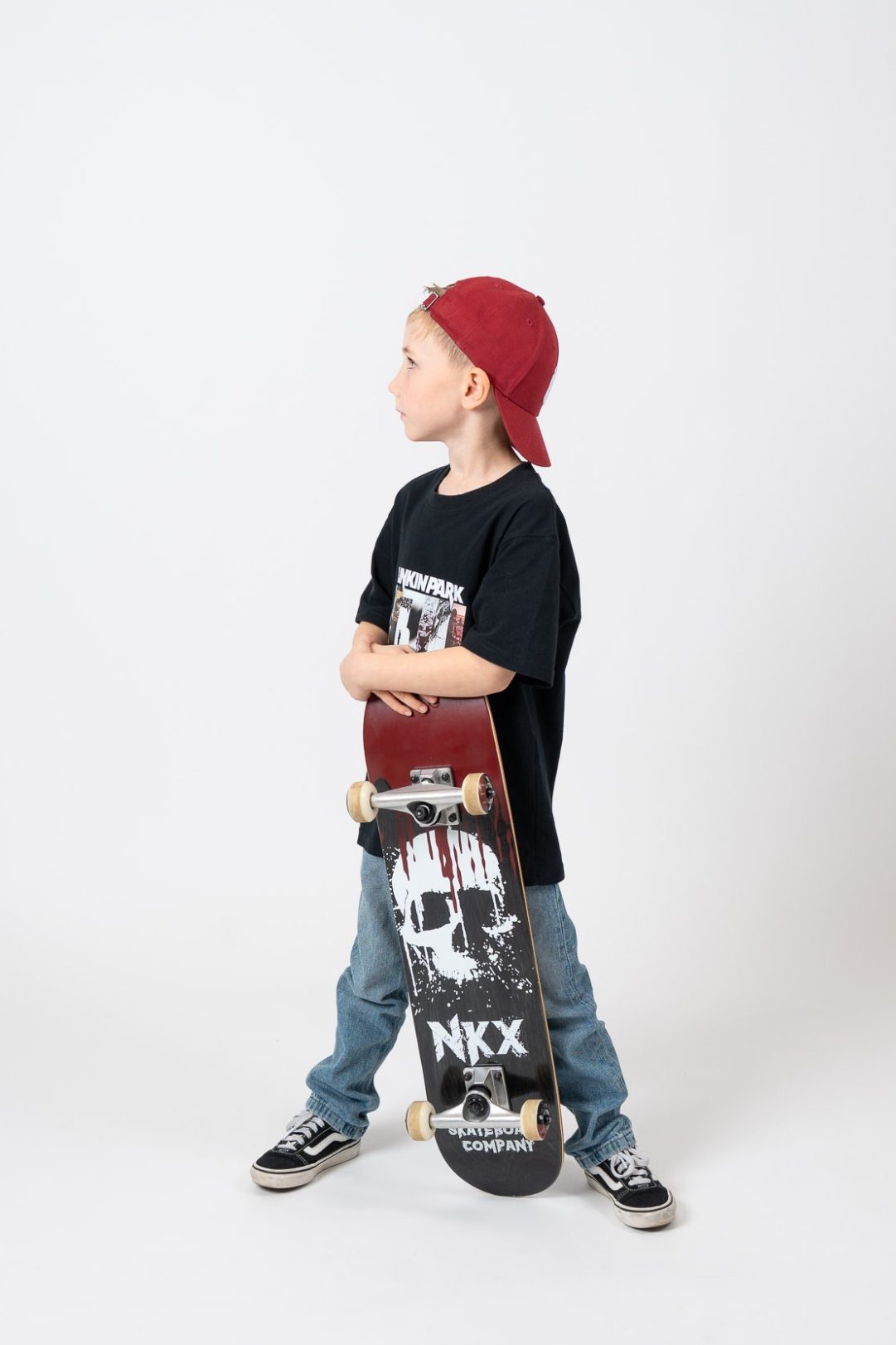 Junge mit Skateboard und Basecap posiert im AuraMirror Self Studio Leipzig